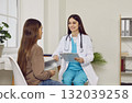 Child girl patient having conversation with woman pediatrician in medical office 132039258
