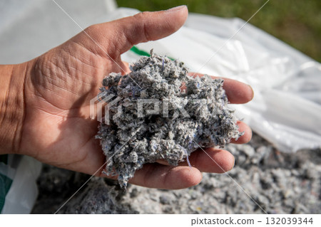 Hand holding cellulose insulation material made from recycled paper 132039344