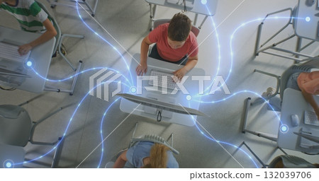 Multiple Pupils Work on Desktop Computers at Personal Tables, Visually Connected by Glowing Lines 132039706