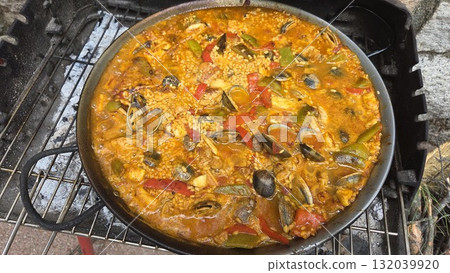 Traditional spanish paella with seafood and vegetables on outdoor grill. Typical cuisine of Spain. Valencian cuisine. Stage of cooking paella. Ingredients for paella 132039920