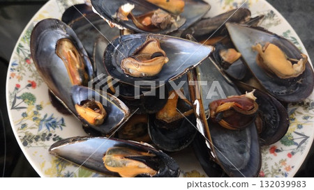 Freshly cooked mussels on decorative plate for seafood dining experience Freshly cooked mussels on decorative plate for seafood dining experience 132039983