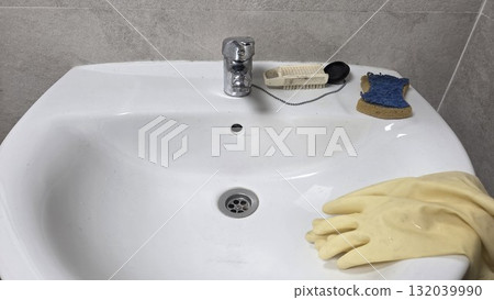 Efficient bathroom cleaning with rubber gloves and sponge for hygiene and freshness Efficient bathroom cleaning with rubber gloves and sponge for hygiene and freshness 132039990