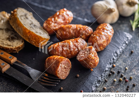 Photo of roasted italian sausage salsiccia on cutting board on black table. 132040227
