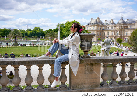 Smiling woman sitting on balustrade in Luxembourg Gardens Paris 132041261
