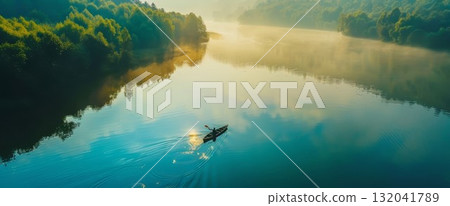 Peaceful lake with small boat in foggy woodland. Tranquil nature view with green trees and calm water in mist. 132041789