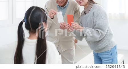 Grandparents giving New Year's gifts to their grandchildren Grandparents giving New Year's gifts to their grandchildren 132041843