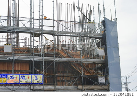 Apartment building construction site (external scaffolding) image during framework construction Apartment building construction site (external scaffolding) image during framework construction 132041891