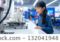 Young Asian girl fascinated by 3D printed cat in workshop 132041948