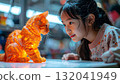 Young Asian girl captivated by a glowing 3D printed cat 132041949