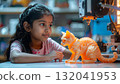 Young Asian girl captivated by a glowing 3D printed cat 132041953