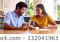 Couple checking blood pressure at home with a monitor 132041963