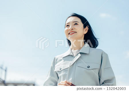 Female worker looking up at the sky 132042003