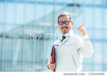 A man in work clothes standing at a construction site 132042009