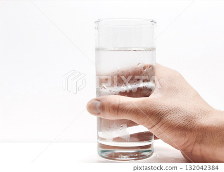 Hand holding a glass of water on a white background Hand holding a glass of water on a white background 132042384