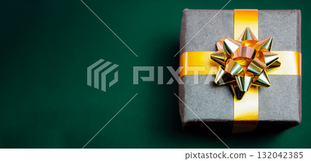 Christmas gift with a beautiful bow on a green background 132042385