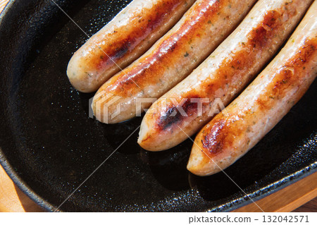 Sausages grilled on an iron plate 132042571