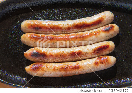 Sausages grilled on an iron plate 132042572