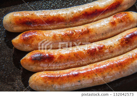 Sausages grilled on an iron plate 132042573
