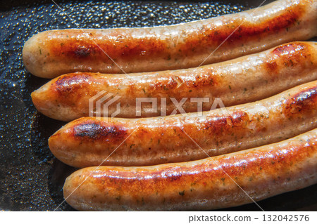 Sausages grilled on an iron plate 132042576