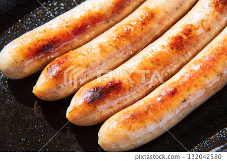 Sausages grilled on an iron plate 132042580