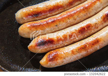 Sausages grilled on an iron plate 132042622