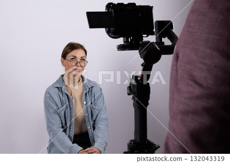 A journalist is being interviewed on camera in a studio setting 132043319