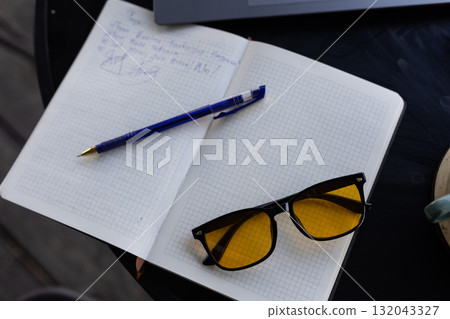 Notebook, pen and glasses on table 132043327