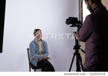 A photographer conducts a photojournalistic interview with a subject in a studio setting A photographer conducts a photojournalistic interview with a subject in a studio setting 132043328