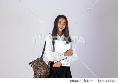 The girl is standing and holding a notebook and a pen The girl is standing and holding a notebook and a pen 132043352