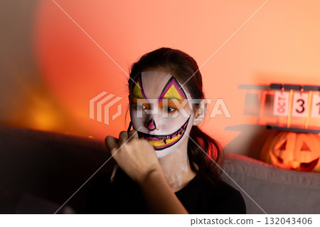 A person is applying Halloween-themed makeup to their face 132043406