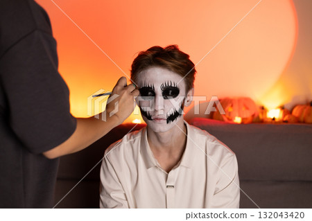 Woman displays skeleton face paint,contrasting light and hues for a Halloween Woman displays skeleton face paint,contrasting light and hues for a Halloween 132043420