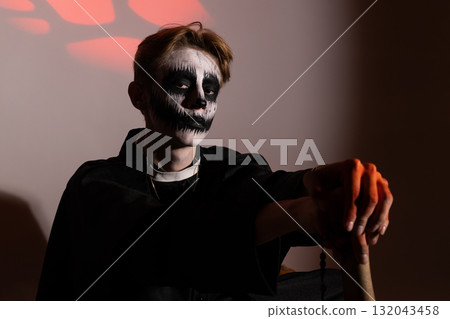 Young vampire boy holding a bat, ready for trick-or-treating on Halloween night 132043458