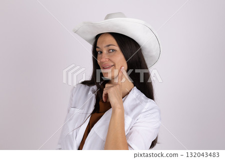 Woman wearing a white cowboy hat in a vibrant rodeo arena 132043483