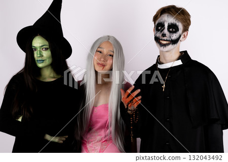 Three people in Halloween costumes are posing for a photo 132043492