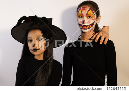 girls in Halloween costumes laughing together in a pumpkin patch girls in Halloween costumes laughing together in a pumpkin patch 132043535
