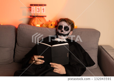 A man in a skeleton mask reading a book A man in a skeleton mask reading a book 132043591