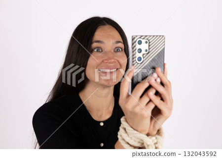 a girl with her hands tied in ropes wants to make a call for help. a girl with her hands tied in ropes wants to make a call for help. 132043592