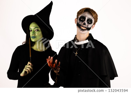 Two people in Halloween costumes,a witch and a skeleton,are posing for a picture Two people in Halloween costumes,a witch and a skeleton,are posing for a picture 132043594