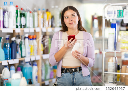 Checking expiration date of body deodorant - female shopper scans QR code on label of body deodorant using smartphone 132043937