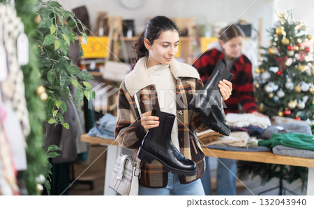 Armenian girl near showcase pick out and buying autumn platform boots, New Year eve Armenian girl near showcase pick out and buying autumn platform boots, New Year eve 132043940