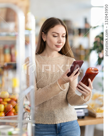 Young woman scanning qr code for ketchup Young woman scanning qr code for ketchup 132043950