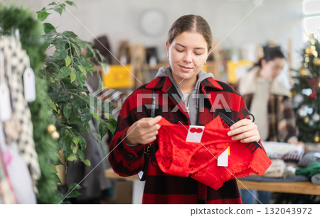 European girl near showcase pick out and buying traditional red ladys panties, New Year eve European girl near showcase pick out and buying traditional red ladys panties, New Year eve 132043972