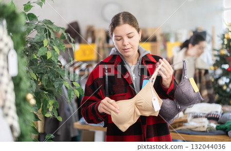 European woman choosing a bra in a store decorated for the new year European woman choosing a bra in a store decorated for the new year 132044036