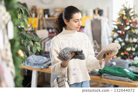 Young Armenian girl choosing hat in clothing store 132044072