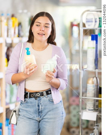 Young woman buyer chooses liquid soap in store 132044096