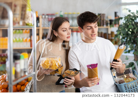 Couple young man and woman choosing pasta Couple young man and woman choosing pasta 132044173