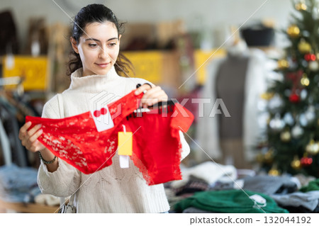 Happy young Armenian girl choosing red panties in clothing store 132044192