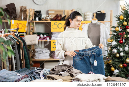 Armenian girl near showcase pick out and buying jeans, New Year eve Armenian girl near showcase pick out and buying jeans, New Year eve 132044197