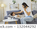 Phone call to pediatric doctor from mother, checking hot forehead of sick child 132044292