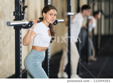 Young woman training with barbell in gym Young woman training with barbell in gym 132044363